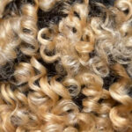 Photograph of Black woman's curled hair, using flexi rod sets.